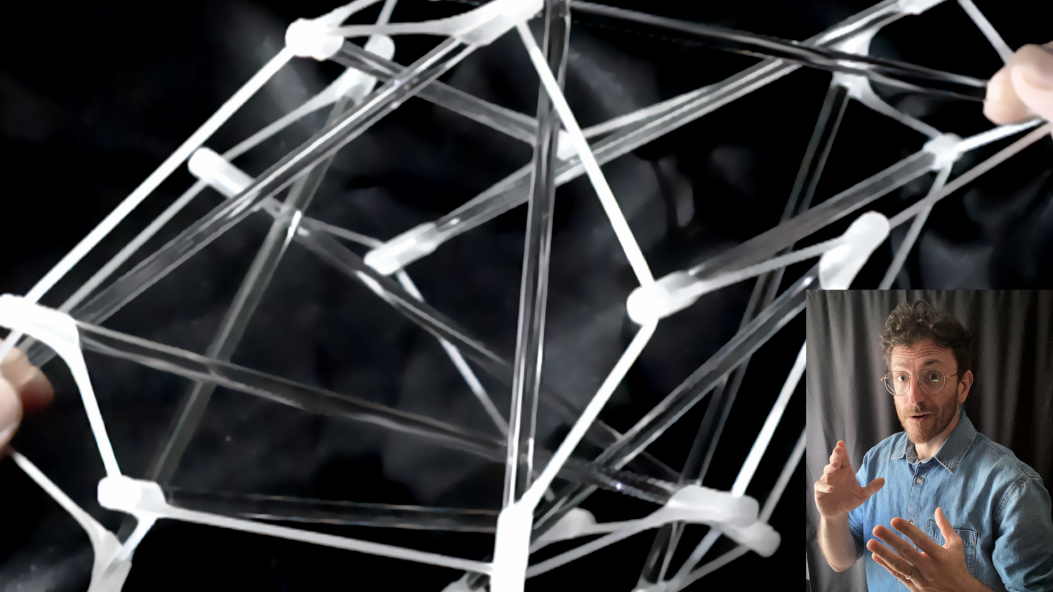 Geometric structure made of clear rods with a person in a small inset showing gestures.